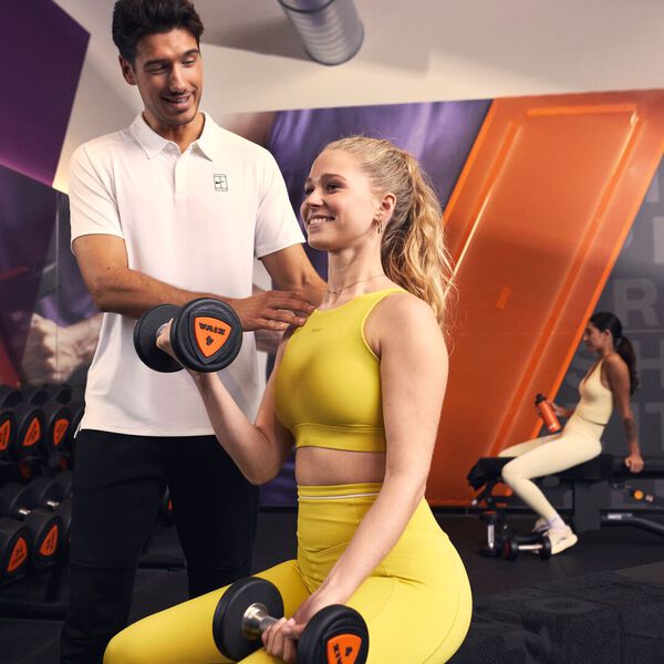 Physical Therapists helping his client executing the bicep curl correctly to reduce pain